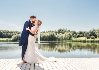 Bride and Groom Embrace by Lake at Waterton Park Hotel